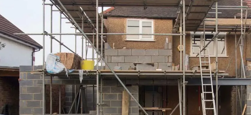 Modern extension with sliding glass doors and a stone-paved patio built by Drivers Building & Roofing.