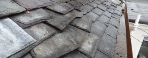 Slate roofing tiles being repairs on a wooden framework by Drivers Building & Roofing.